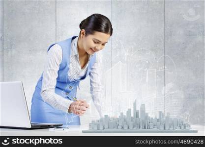 Modern construction development design. Young smiling businesswoman working with modern real estate concept