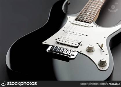 Modern electric guitar, black background, nobody. String musical instrument, electro sound, electronic music, equipment for stage concert. Modern electric guitar, black background, nobody