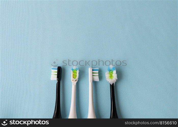 Modern electric toothbrush on a blue background, it’s time to change the brush - old and new brush attachment. Hygiene concept for daily oral care. Modern electric toothbrush on a blue background, it’s time to change the brush - old and new brush attachment. Hygiene concept for daily oral care.