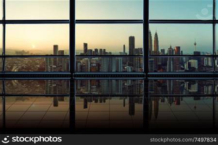 Modern empty and clean office interior with glass windows and city skyline background , early morning scene .