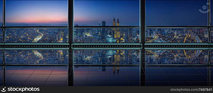 Modern empty and clean office interior with glass windows and city skyline background , night scene .