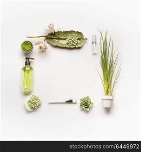 Modern facial skin care setting . Herbal cosmetic concept. Frame of green cosmetic products, accessories, plants and orchid flowers on white desktop background, top view, copy space, flat lay