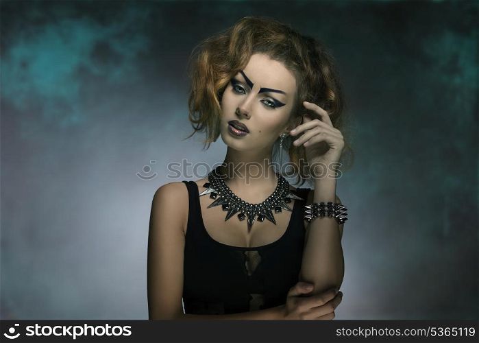 modern fashion portrait of sexy punk girl with creative make-up, dark dress and studs accessories