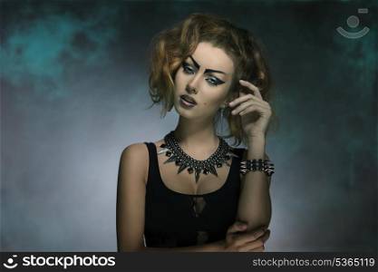 modern fashion portrait of sexy punk girl with creative make-up, dark dress and studs accessories