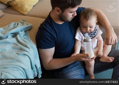 Modern father playing with little baby boy
