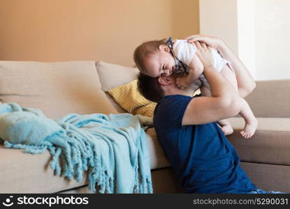 Modern father playing with little baby boy