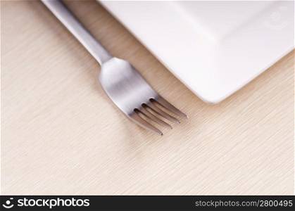 Modern fork and plate on wooden table