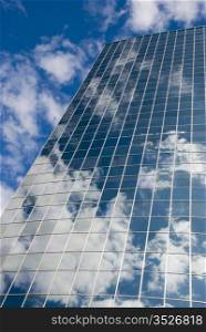 Modern glass and steel skyscraper. Sky reflection in the modern office glass building.