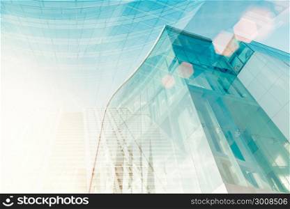 Modern glass building with sun flare. Soft focus of city for abstract background.