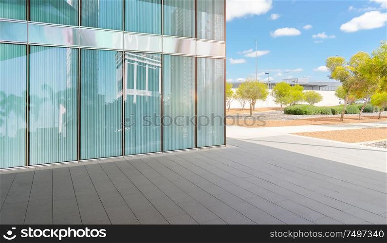 Modern glass facade office building and ground with beautiful sunny garden background