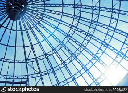 Modern glass roof with blue sky and sun