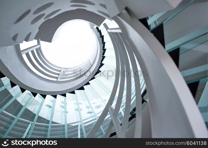 modern glass spiral staircase with metallic hand-rails.