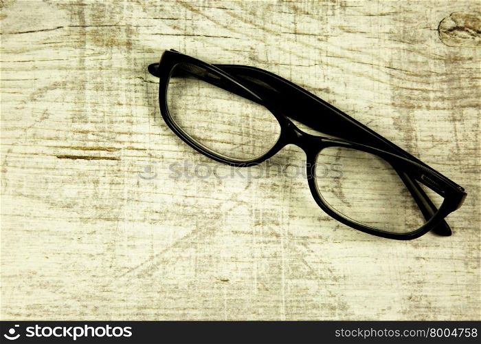 Modern glasses on an old, wooden, light countertop in a vintage style. Close horizontal view.