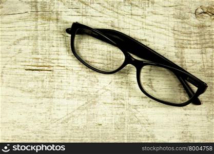 Modern glasses on an old, wooden, light countertop in a vintage style. Close horizontal view.