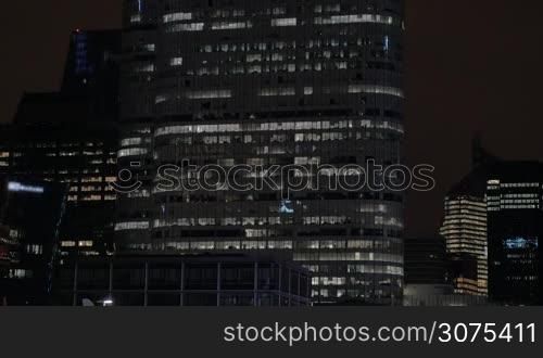 Modern glassy skyscrapers illuminated at night. Modern city architecture