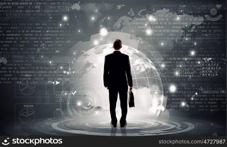 Modern global technologies. Back view of businessman with suitcase in hands looking at virtual panel