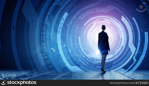 Modern global technologies. Back view of businesswoman with suitcase in hands looking at virtual panel