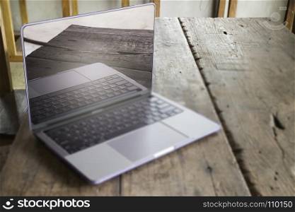 Modern grey metal laptop on wooden table, stock photo