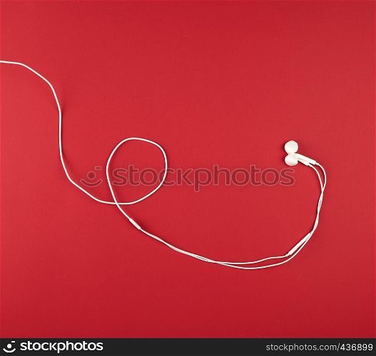 modern headphones with white cable on red background