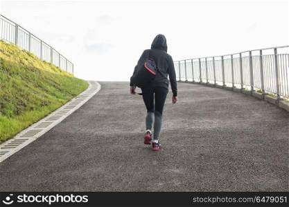 Modern healthy lifestyle. A woman in sportswear climbs the hill