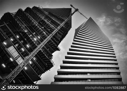 Modern higher buildings in black and white with a building crane.