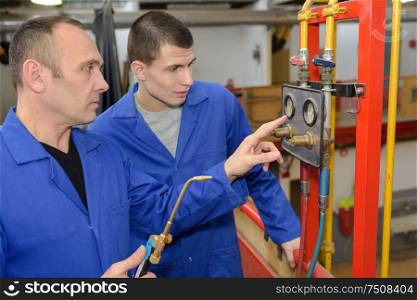 modern industrial machine operator working with apprentice