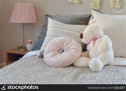 modern kids room with doll and pillows on bed