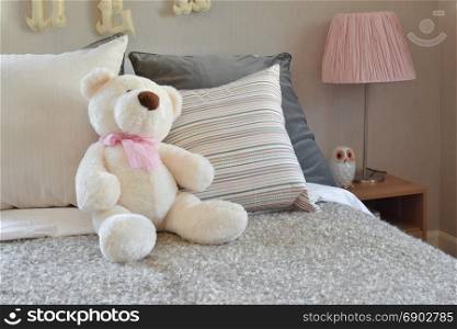 modern kids room with doll and pillows on bed