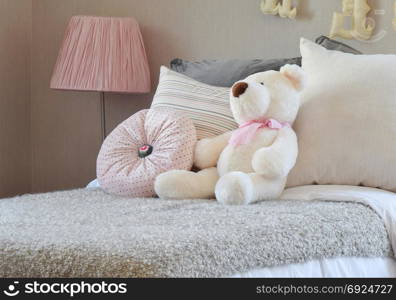 modern kids room with doll and pillows on bed