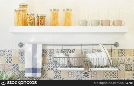 modern kitchen with ceramic kitchenware and utensils on the shelf