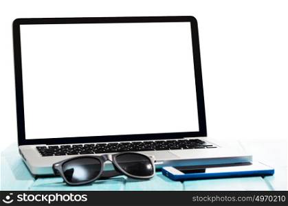 Modern laptop computer, top view. Work on the go. Modern laptop computer with smartphone and sunglasses on blue table