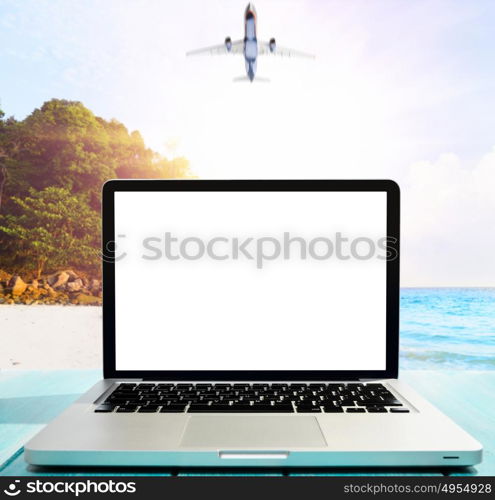 Modern laptop on blue wooden table with blank screen at tropical beach. working by the seaside