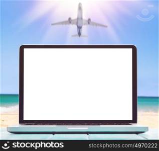 Modern laptop on blue wooden table with blank screen at tropical beach. working by the seaside