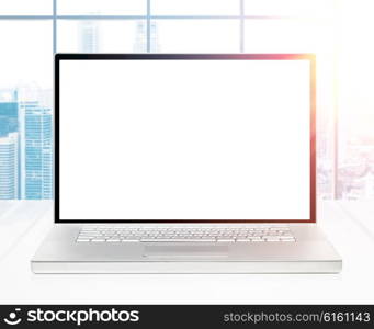 modern laptop with blank screen on office desk at sunrise. laptop at sunrise office