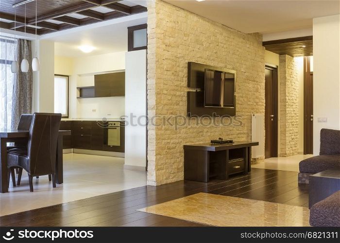 modern living room and modern kitchen. The wall with natural stone bricks and tv on it.