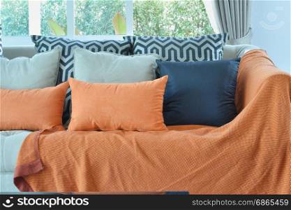 modern living room design with brown and orange tweed sofa and black pillows