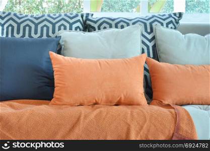 modern living room design with brown and orange tweed sofa and black pillows