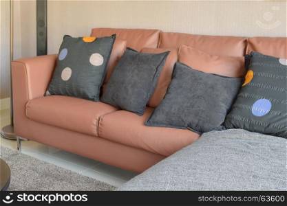 modern living room design with brown leather sofa and black pillows