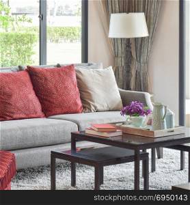 modern living room design with red pillows on sofa and decorative tea set on table