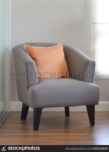 modern living room interior with orange pillow on grey armchair