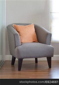 modern living room interior with orange pillow on grey armchair