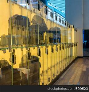 Modern luggage storage solution in airport with glass boxes for carry-on bags. Luggage stored in transparent glass boxes in airport lounge
