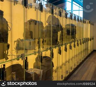 Modern luggage storage solution in airport with glass boxes for carry-on bags. Luggage stored in transparent glass boxes in airport lounge