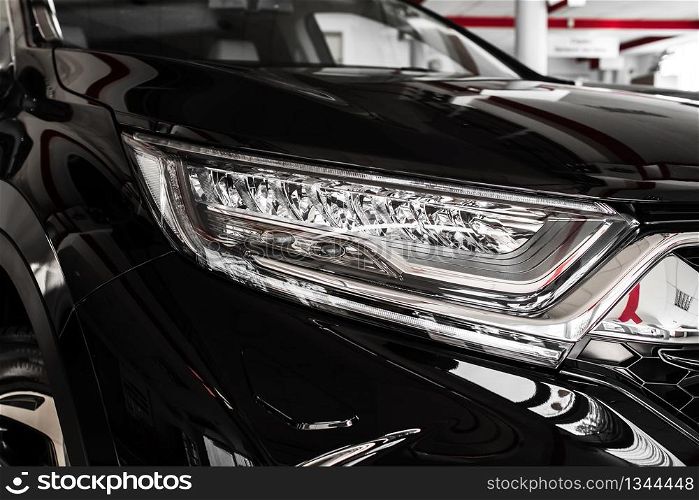 Modern luxury car close-up. Headlight lamp of new cars,copy space. A modern and elegant car illuminated. selective focus