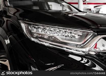 Modern luxury car close-up. Headlight lamp of new cars,copy space. A modern and elegant car illuminated. selective focus