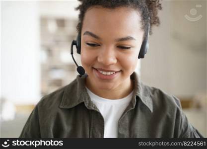 Modern mixed race teen girl student wearing headset with microphone learning foreign language online. Happy biracial schoolgirl in headphones studying on the internet. Distance education, e-learning.. Modern mixed race teen girl student wearing headset learning online. Distance education, e-learning