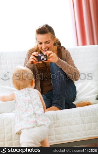 Modern mother making photos of baby at home&#xA;