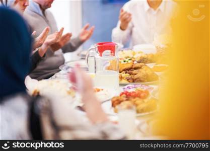modern multiethnic muslim family praying before having iftar dinner together during a ramadan feast at home