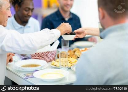 modern multiethnic muslim family sharing a bowl of dates while enjoying iftar dinner together during a ramadan feast at home