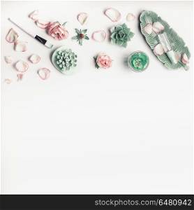 Modern natural cosmetic beauty concept. Skin care equipment with roses , flowers, succulents, facial mist water spray and mask brush on white background, top view, flat lay, border